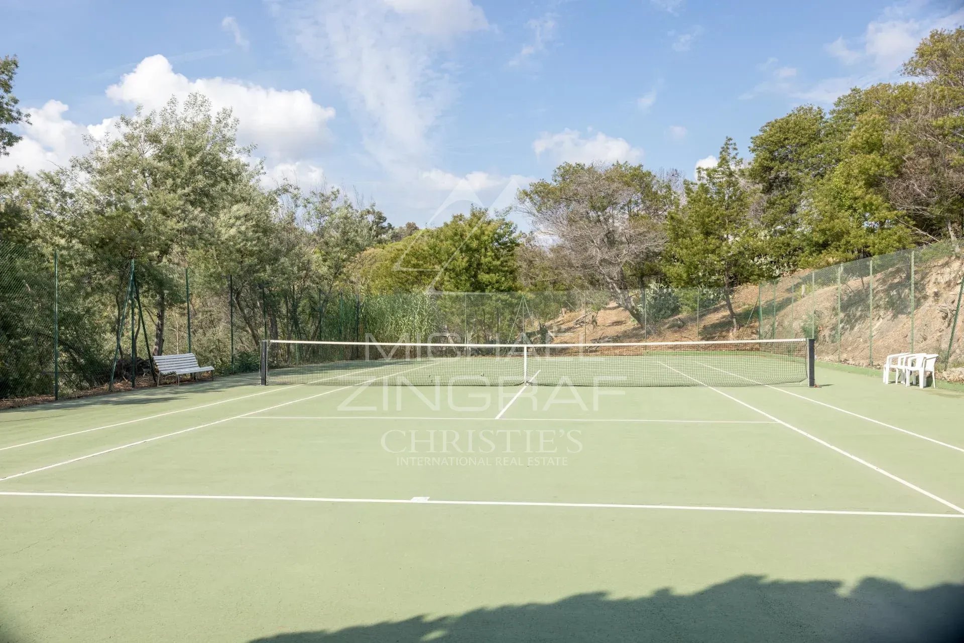 Court de tennis à Cannes Court de tennis dans une résidence à Cannes, quartier Croix des Gardes, entouré d'arbres.