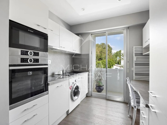Cuisine moderne d'un penthouse à Cannes, avec des appareils électroménagers et une fenêtre donnant sur l'extérieur.