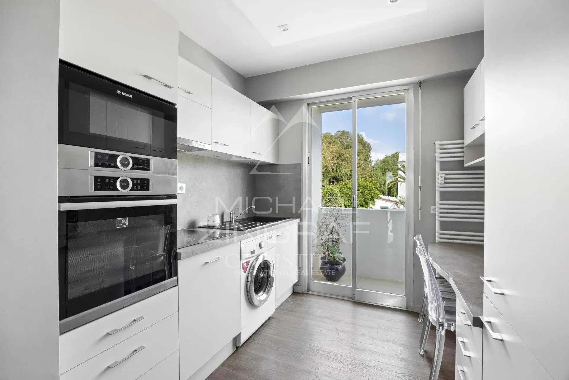 Cuisine du penthouse à Cannes Cuisine moderne d'un penthouse à Cannes, avec des appareils électroménagers et une fenêtre donnant sur l'extérieur.
