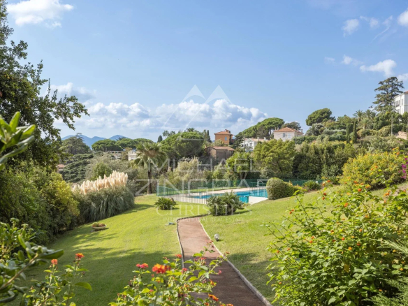 Vue d'un jardin avec piscine et court de tennis dans une résidence à Cannes, Croix des Gardes.