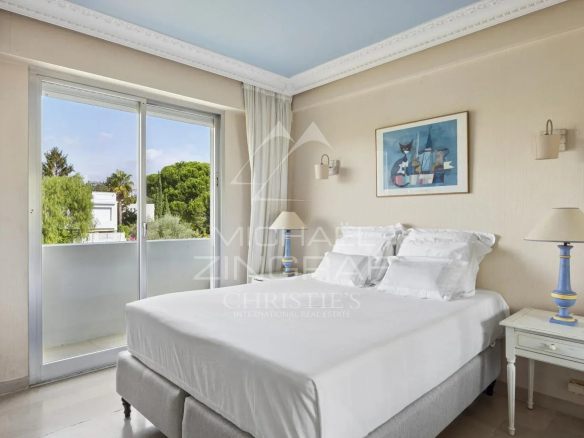 Chambre d'un penthouse à Cannes avec balcon et vue sur la verdure.