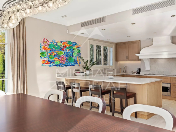 Cuisine moderne avec table à manger et œuvre d'art colorée, dans une propriété de Cannes.
