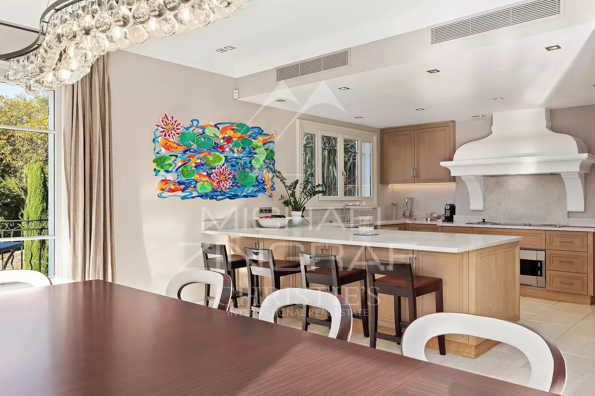 Cuisine de la propriété à Cannes Cuisine moderne avec table à manger et œuvre d'art colorée, dans une propriété de Cannes.