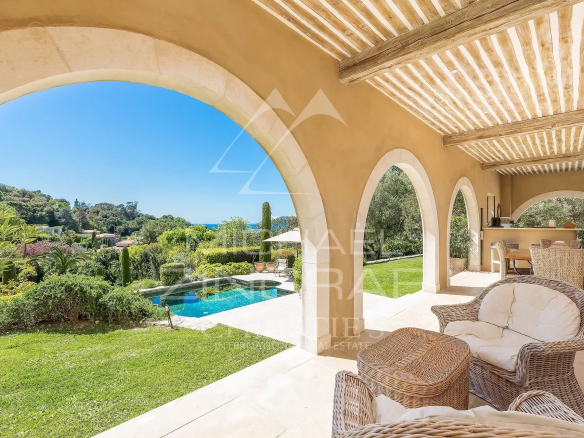 Terrasse d'une propriété toscane à Cannes avec vue sur la piscine et le jardin.