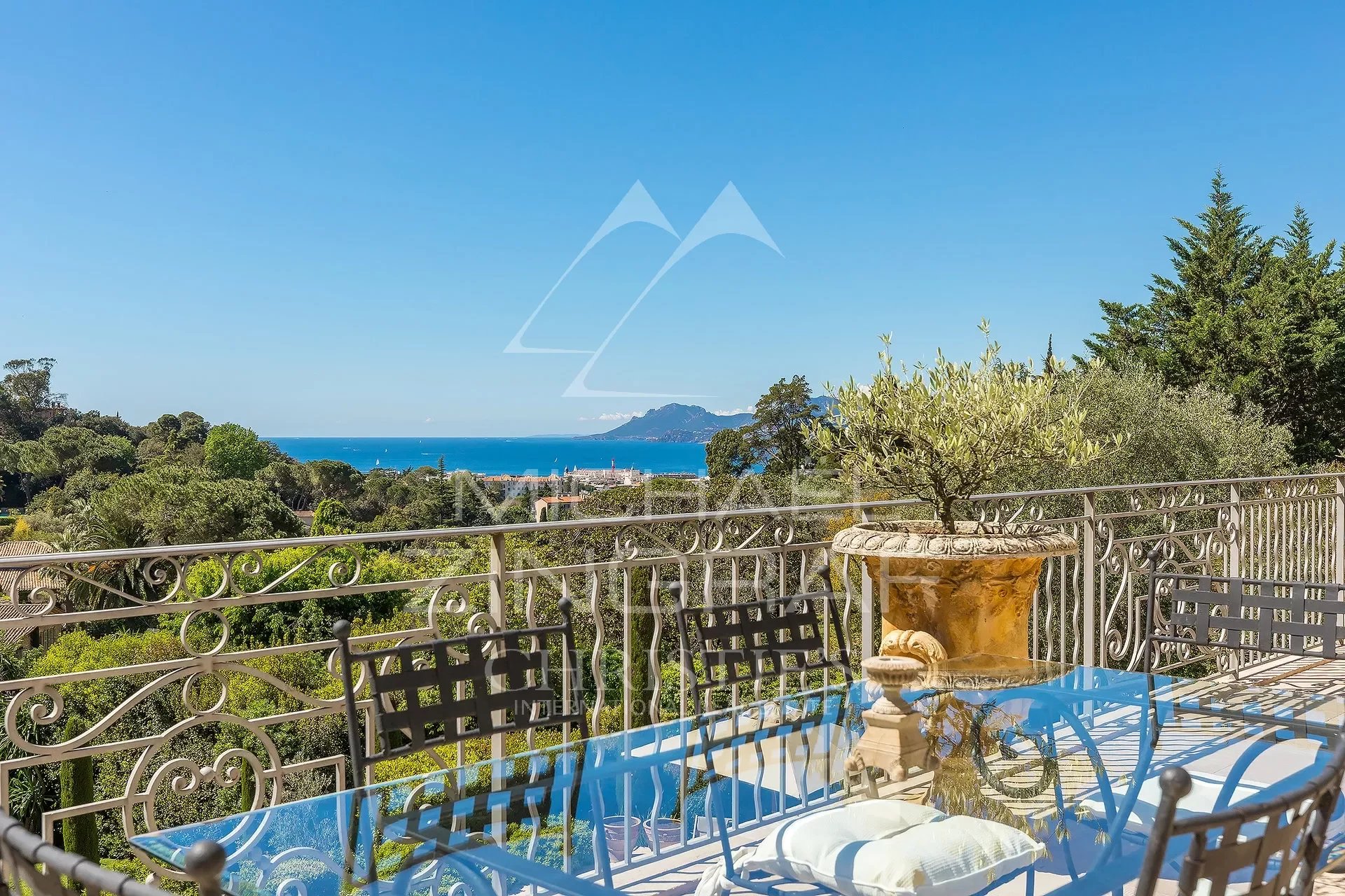 Propriété de luxe à Cannes Vue sur la baie de Cannes depuis une terrasse avec mobilier de jardin.