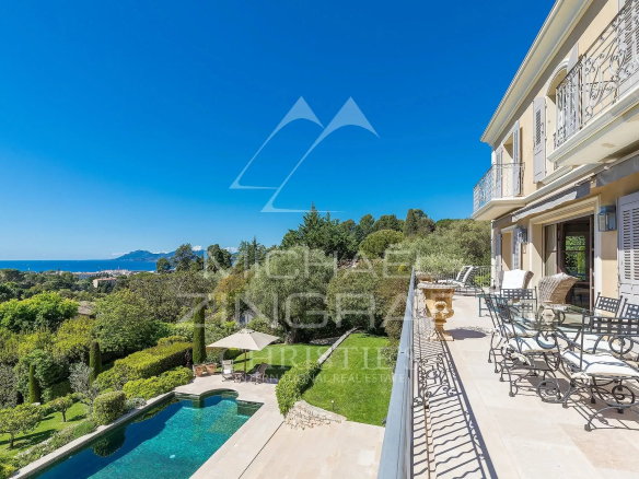 Vue panoramique sur la baie de Cannes depuis une propriété toscane avec piscine et jardin.