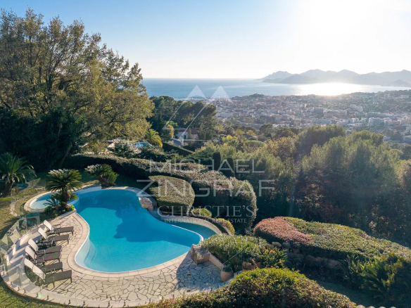 Panoramic views of the sea and the Estérel mountains from a villa in Cannes, with swimming pool and green spaces.