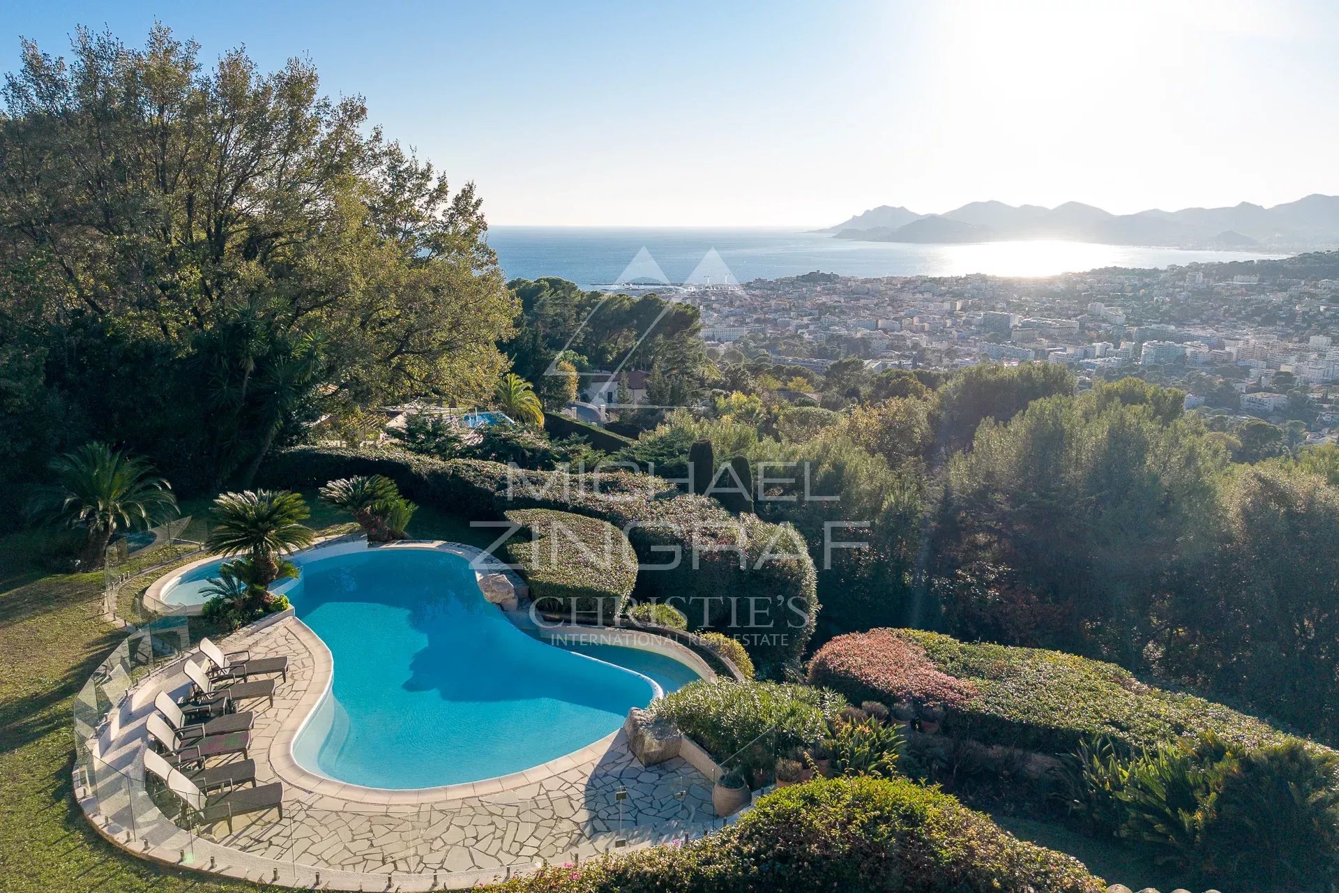 Panoramic views of the sea and the Estérel mountains from a villa in Cannes, with swimming pool and green spaces.
