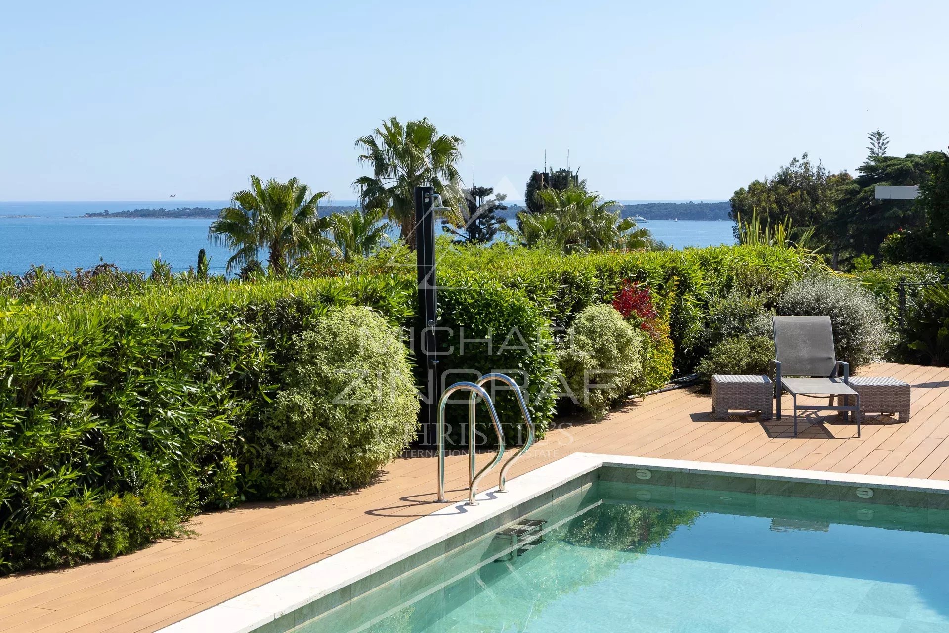 Panoramic sea view at Cannes Eden Panoramic sea view from a villa with pool in Cannes Eden, surrounded by greenery.