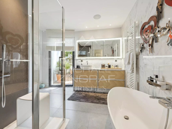 Modern bathroom with shower and bathtub, decorated with contemporary elements.