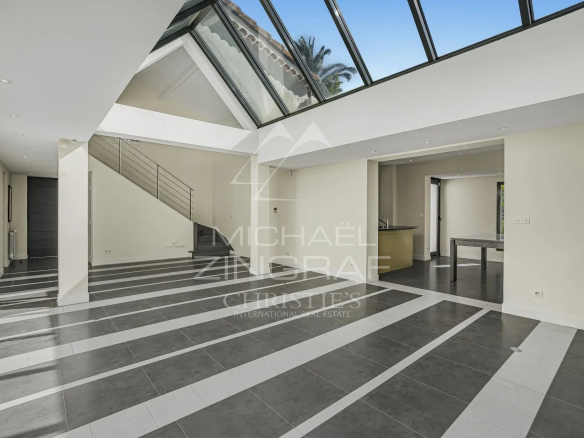 Intérieur d'une villa moderne à Cannes avec de grandes baies vitrées et un sol en carrelage.