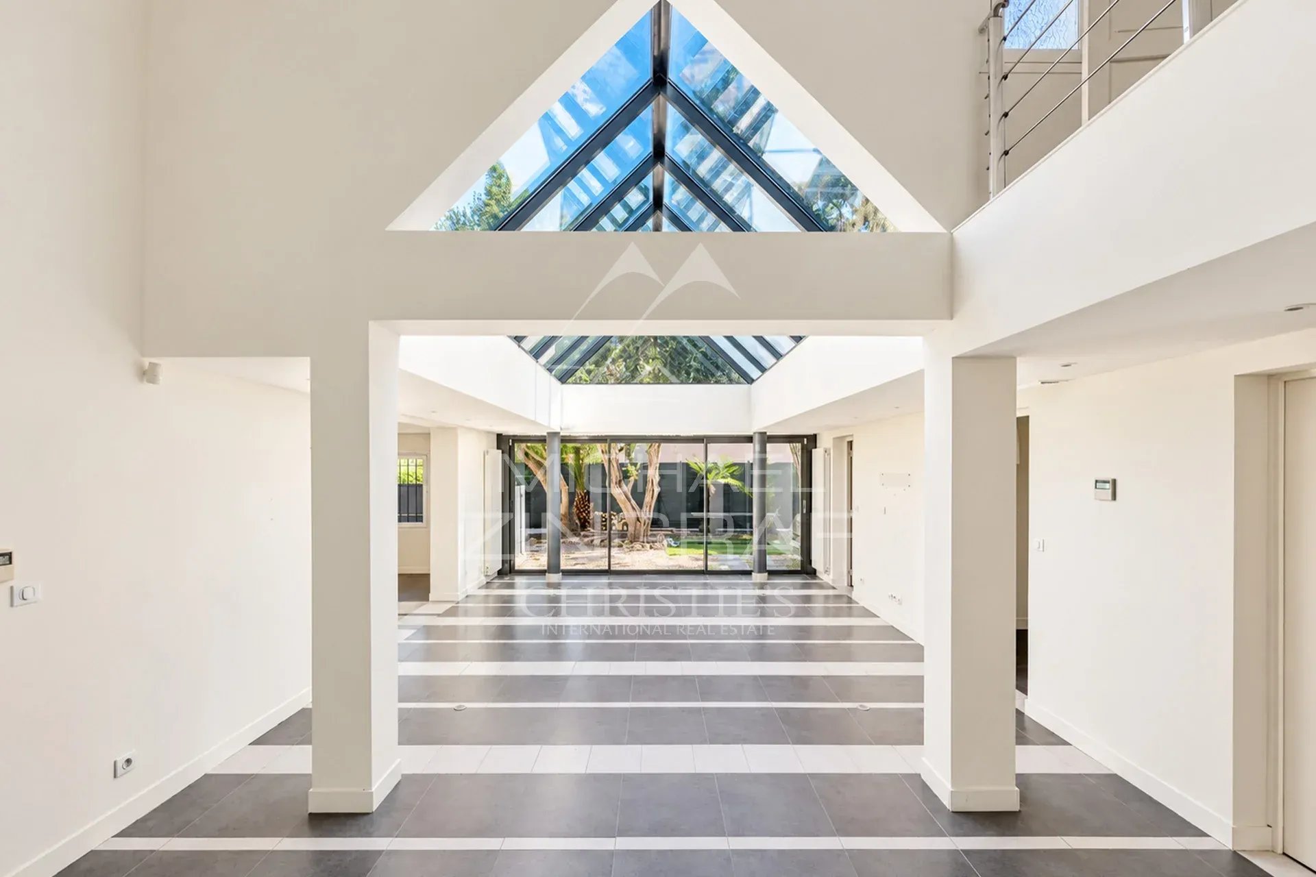 Intérieur d’une villa à Cannes Intérieur d'une villa moderne avec un grand espace ouvert et une verrière au plafond.