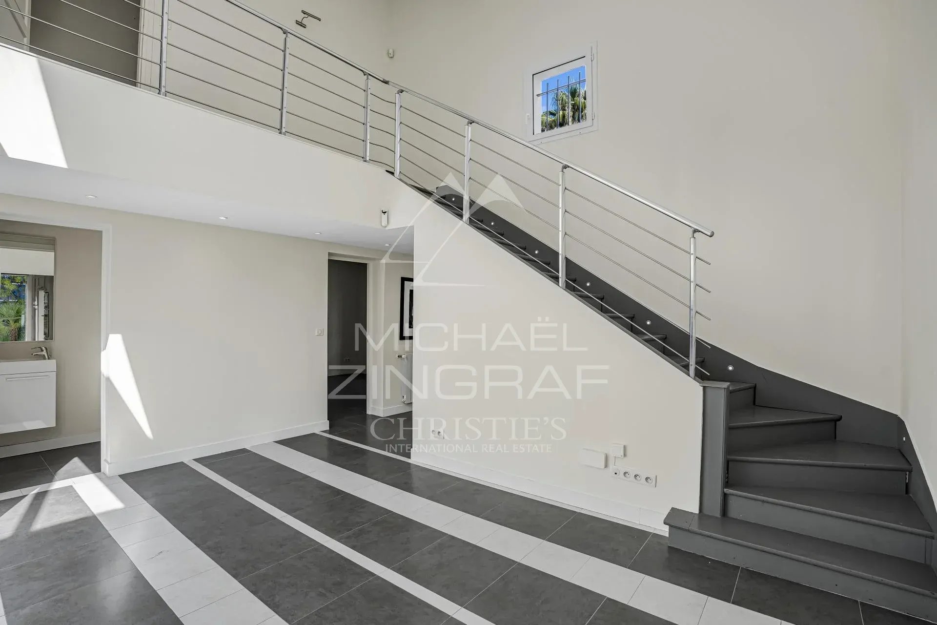 Intérieur d’une villa à Cannes Intérieur d'une villa moderne avec un escalier en colimaçon et de grandes fenêtres.