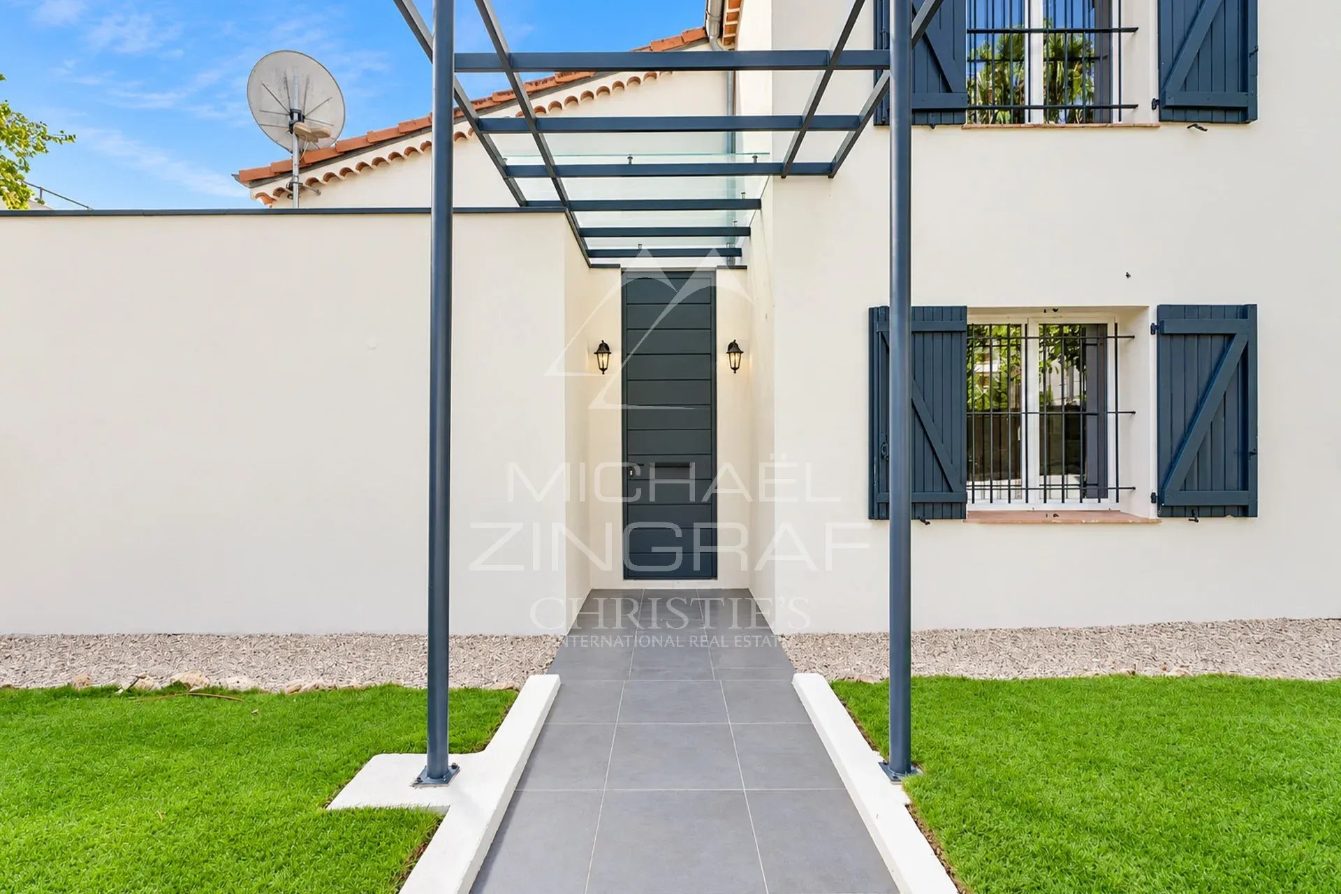 Entrée de villa à Cannes Entrée d'une villa moderne avec un chemin en dalles et un auvent en verre.