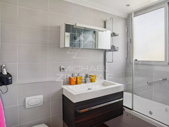 Modern bathroom with shower and bathtub, mirror and vanity unit.