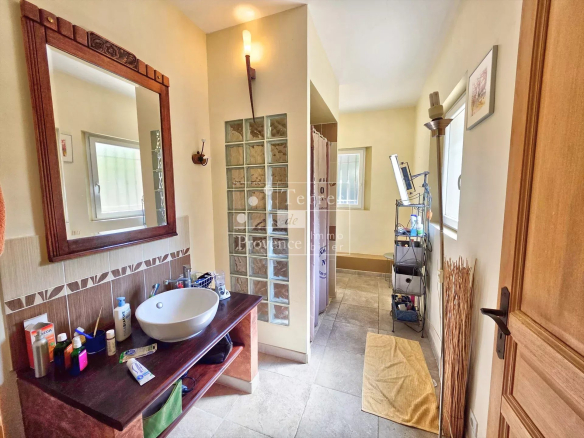 Salle de bain lumineuse avec lavabo et douche dans une villa à Baudinard-sur-Verdon.