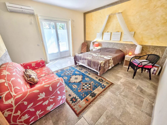Chambre d'une villa à Baudinard-sur-Verdon avec lit, canapé et décoration provençale.