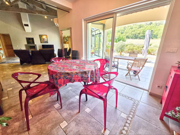 Intérieur d'une villa à Baudinard-sur-Verdon avec table et chaises, vue sur l'extérieur