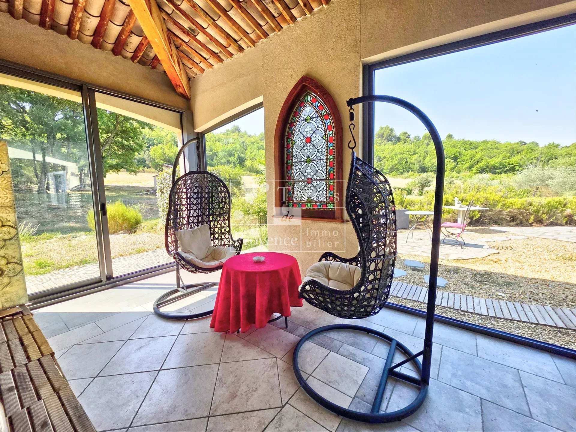 Intérieur de la villa à Baudinard-sur-Verdon Intérieur d'une villa à Baudinard-sur-Verdon avec chaises suspendues et vue sur la nature.