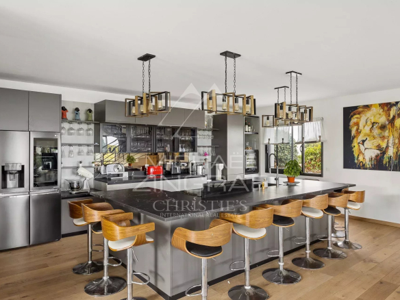 Cuisine moderne et spacieuse avec îlot central et bar, dans une villa contemporaine à Saint-Laurent-du-Var.
