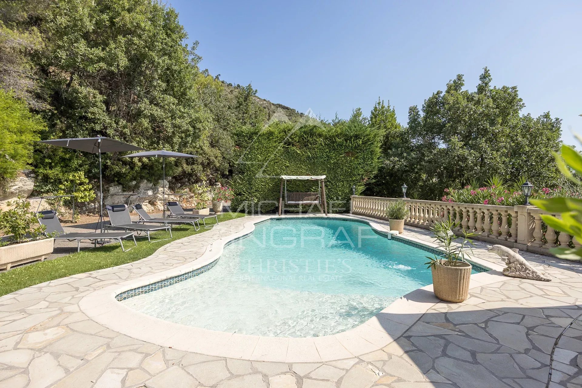 Swimming pool with panoramic views in a property in Aspremont, surrounded by greenery.