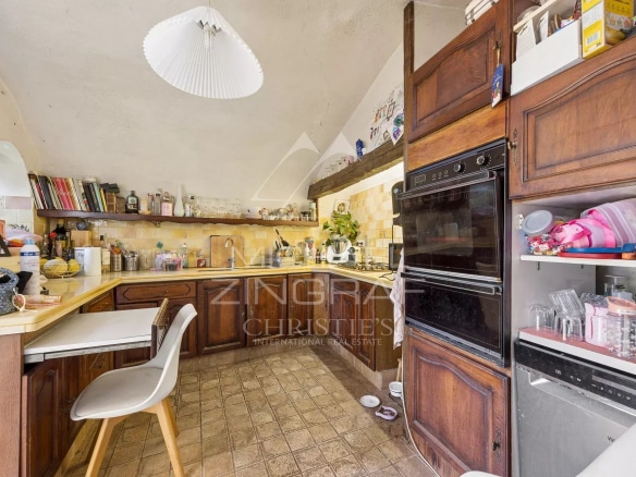 Cuisine d'une bastide du XVIIIᵉ siècle à Nice, avec meubles en bois et équipements modernes.