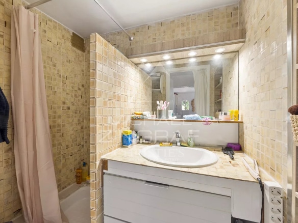 Salle de bain d'une bastide du XVIIIᵉ siècle à Nice, avec carrelage et lavabo.