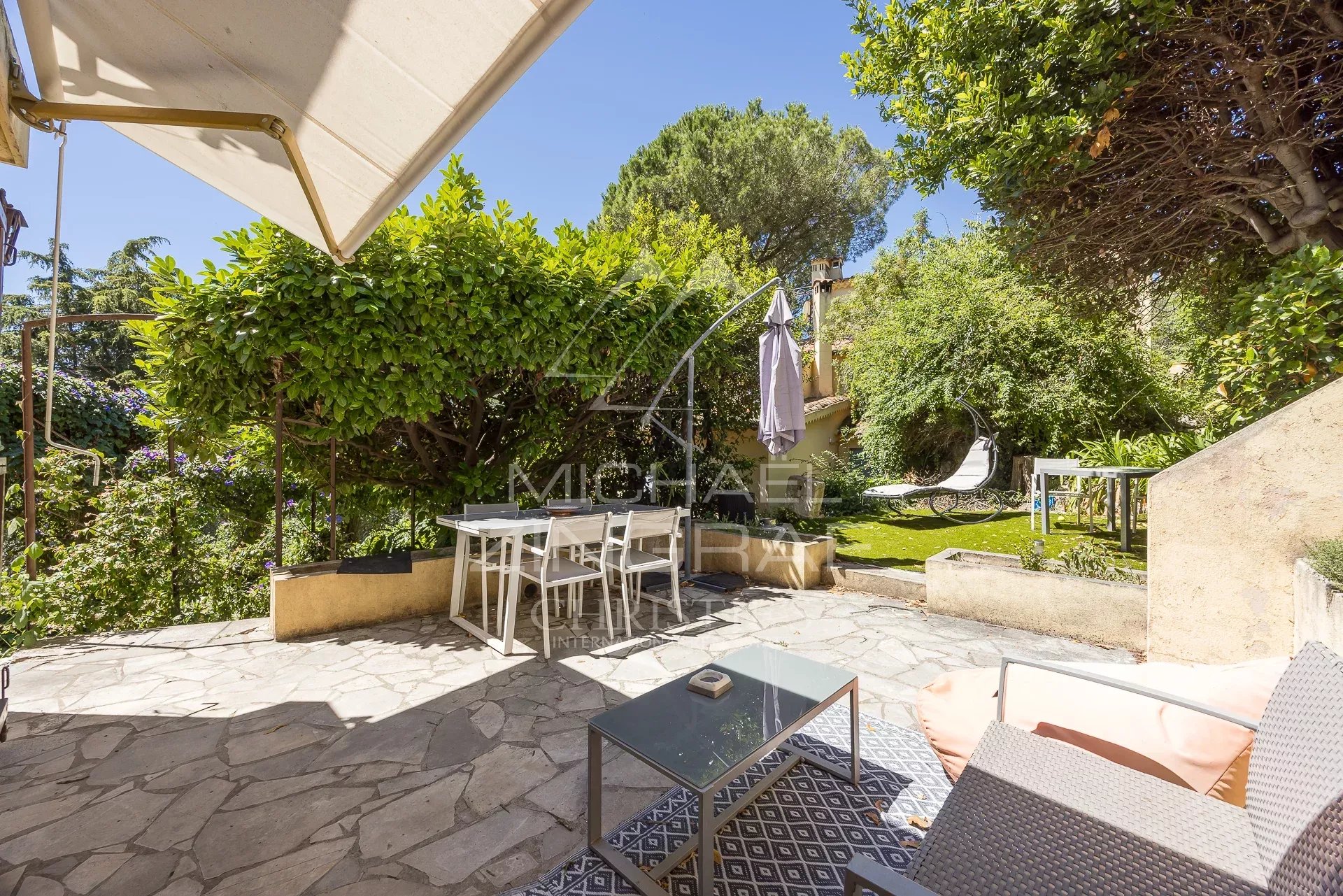 Terrasse d’une bastide à Nice Terrasse en pierre avec mobilier de jardin dans un jardin verdoyant d'une bastide du XVIIIe siècle à Nice.