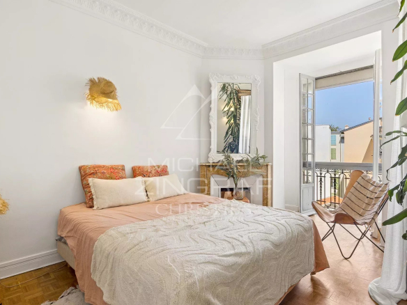 Chambre lumineuse avec lit double et balcon, style bohème chic à Nice.
