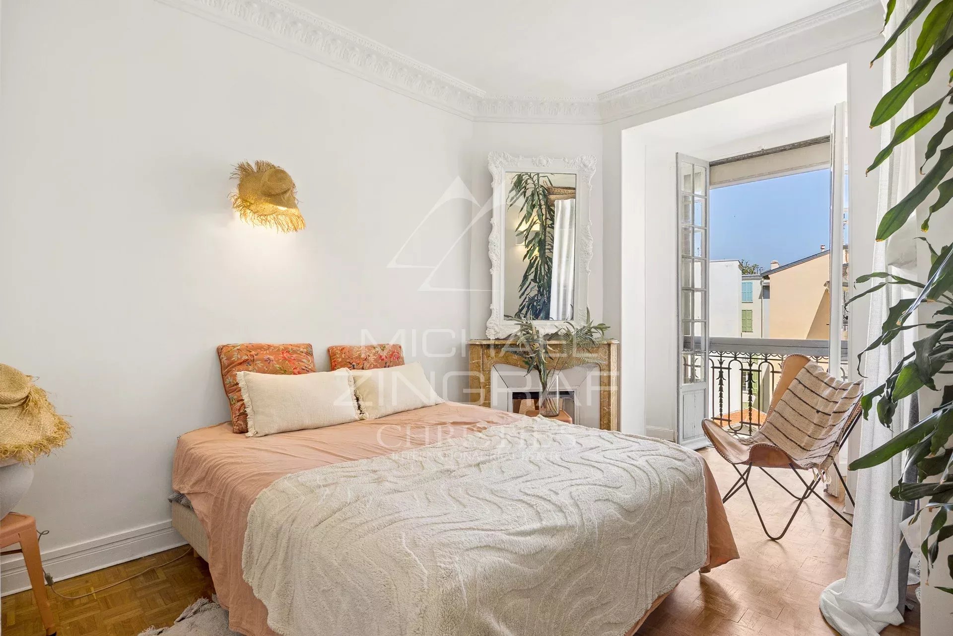 Chambre lumineuse avec lit double et balcon, style bohème chic à Nice.