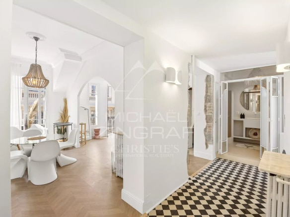 Intérieur d'un appartement au dernier étage avec décoration bohème chic, lumière naturelle et vue sur la mer.