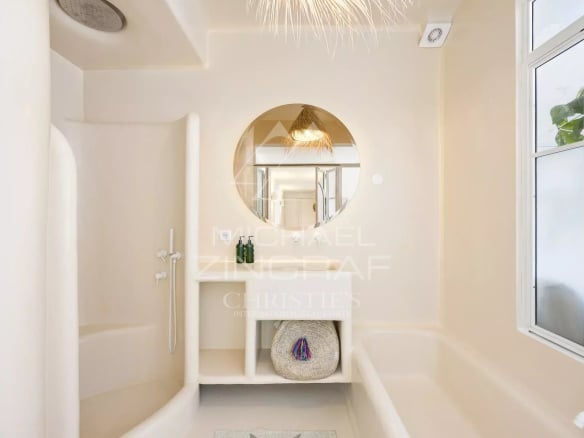 Salle de bain moderne avec douche et baignoire, décoration bohème chic.