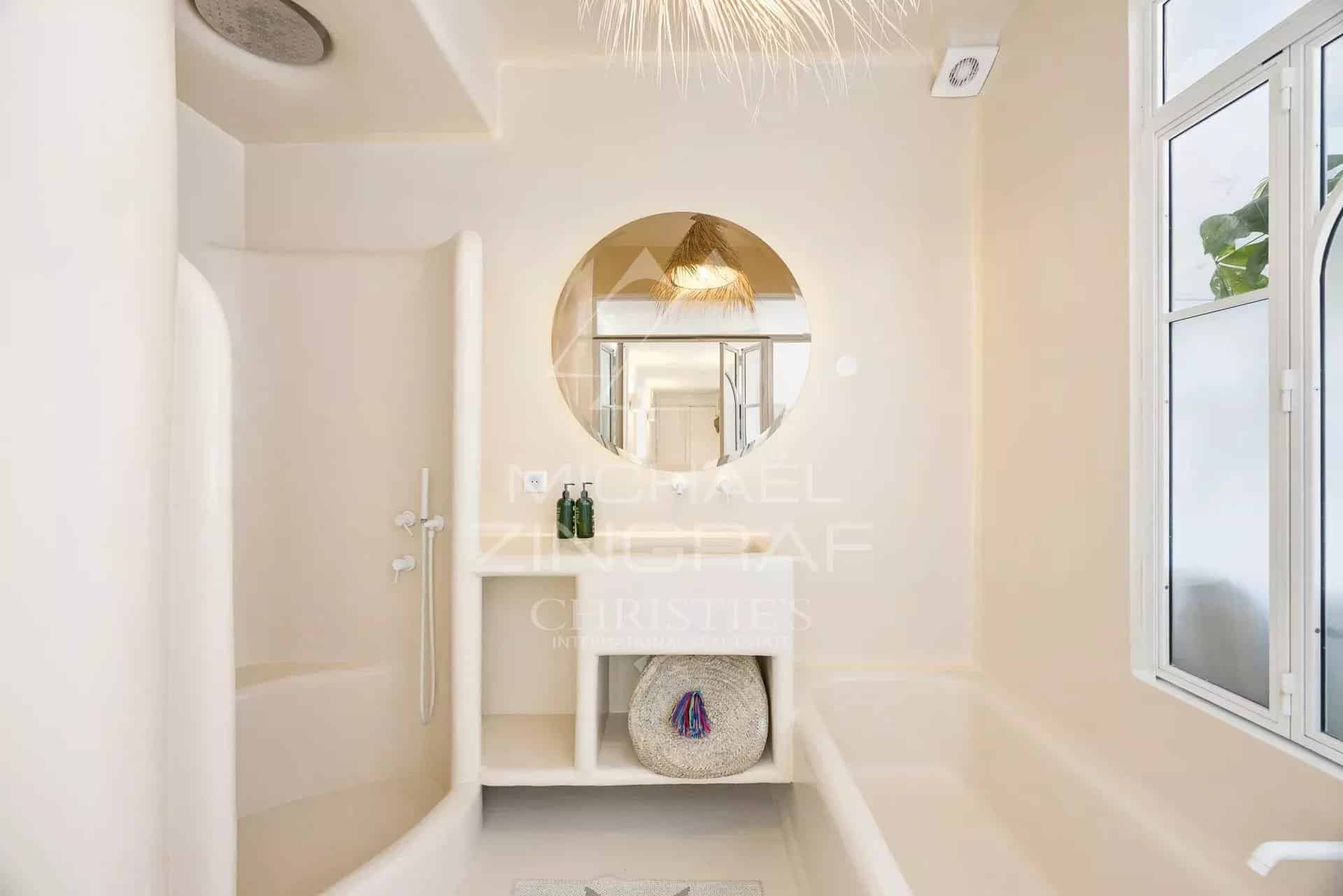 Salle de bain moderne avec douche et baignoire, décoration bohème chic.