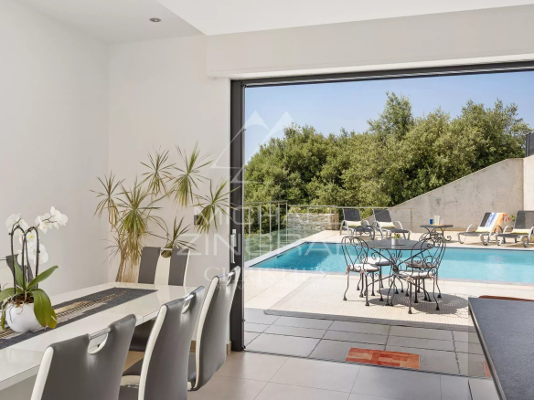 Intérieur d'une villa moderne avec vue sur la piscine et le jardin, à Saint-Jeannet.