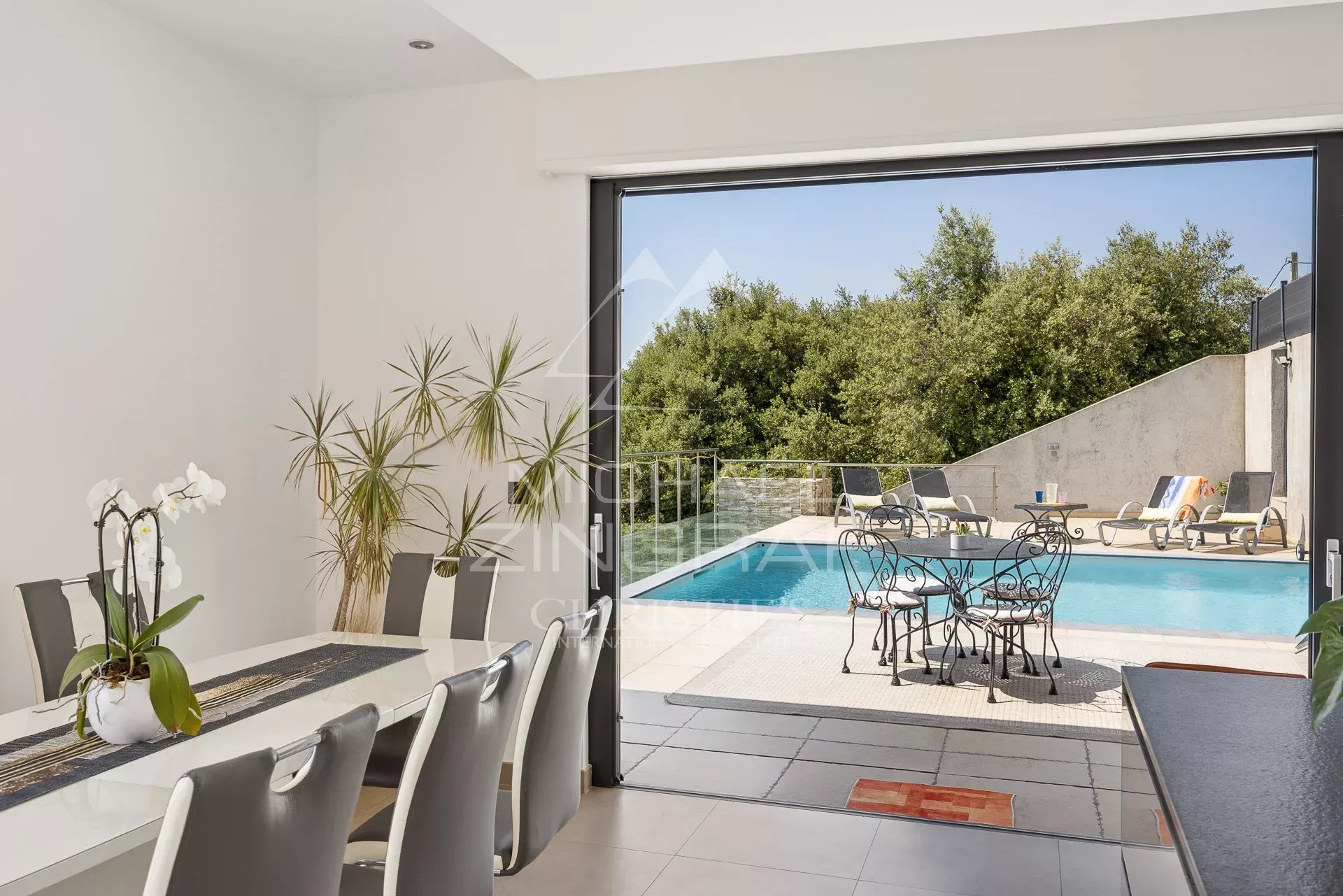 Intérieur d'une villa moderne avec vue sur la piscine et le jardin, à Saint-Jeannet.