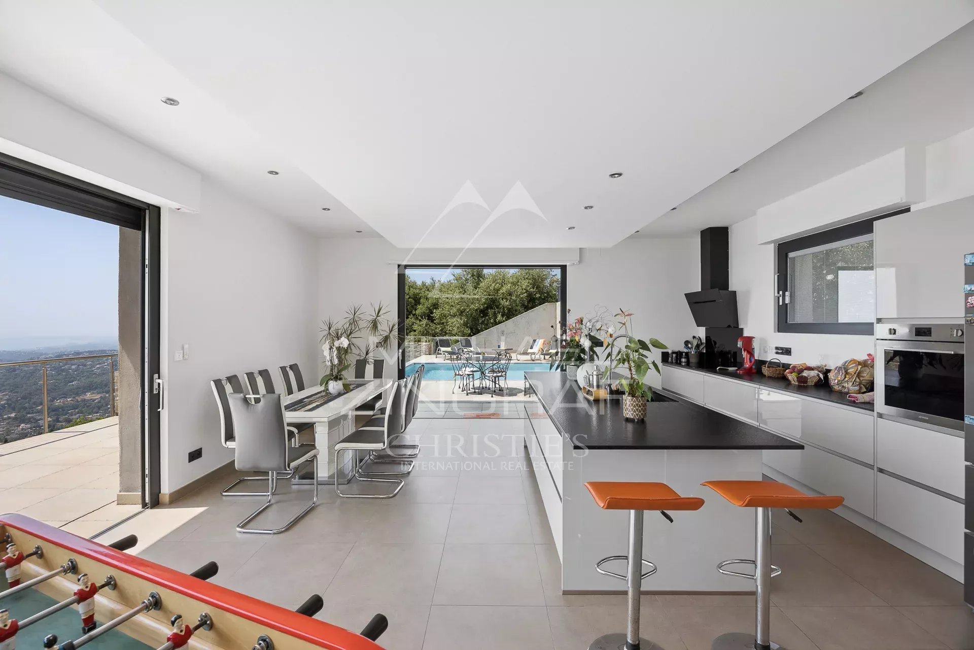 Intérieur d'une villa moderne avec cuisine ouverte et vue sur la mer.