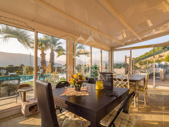 Bright interior of a property in Colomars with views of the pool and hills.
