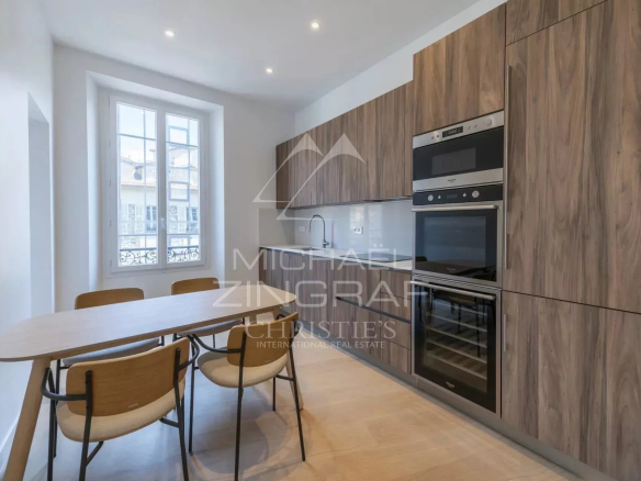 Cuisine moderne avec meubles en bois et appareils électroménagers intégrés dans un appartement rénové.