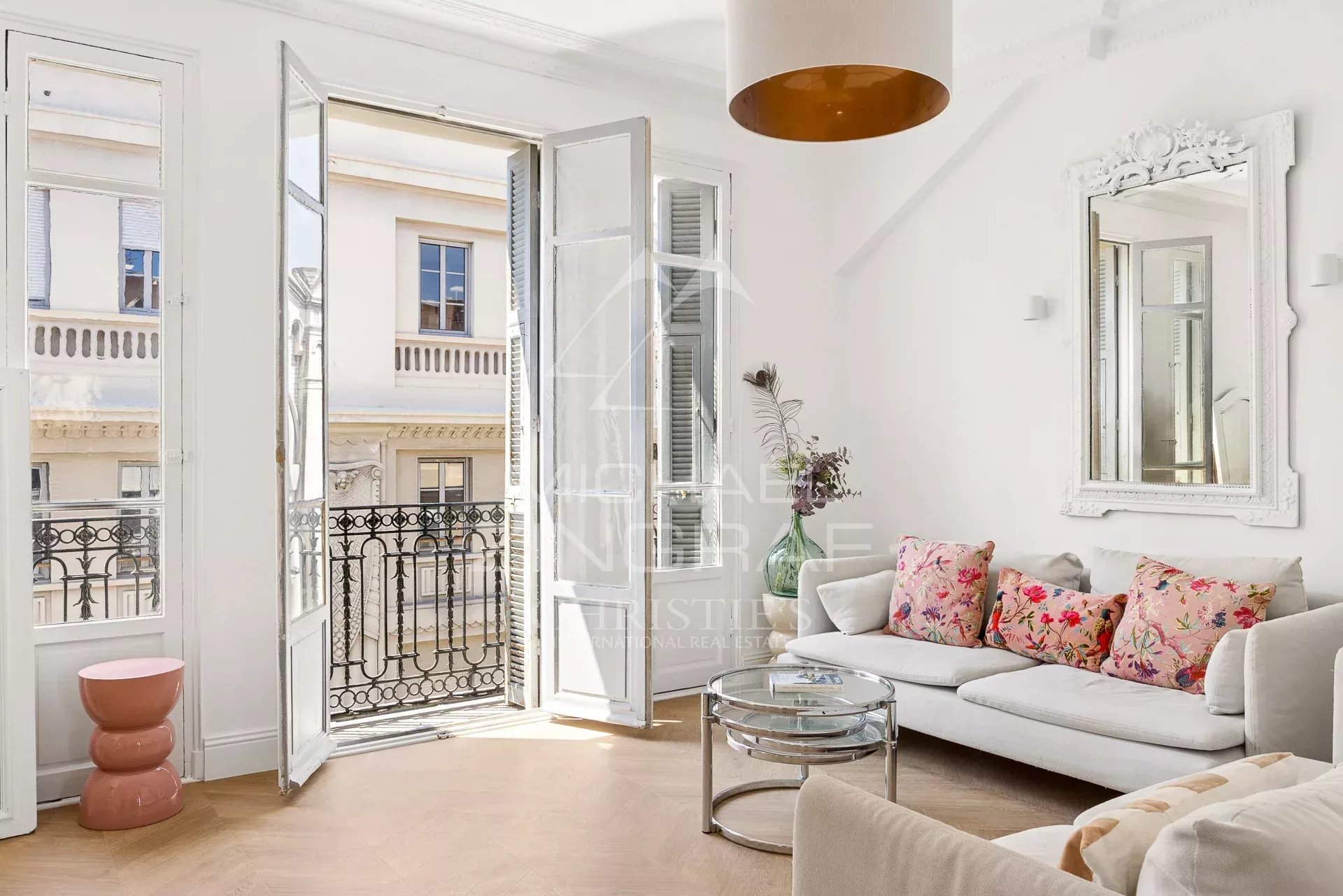 Bright living room of a top-floor apartment with balconies and bohemian decor in Nice.