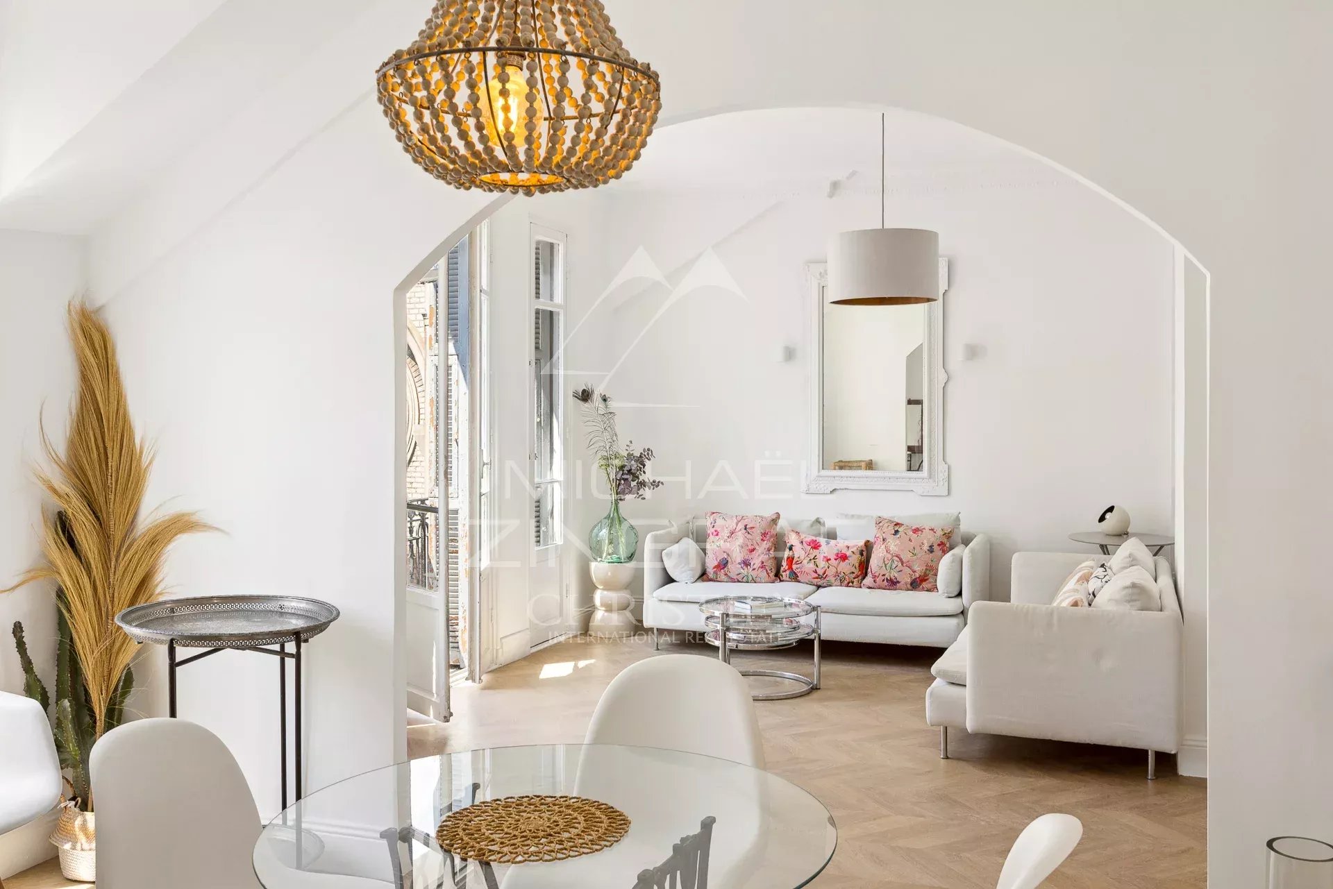 Interior of a bohemian chic apartment with sea views in Nice, bright living room and floral decor.