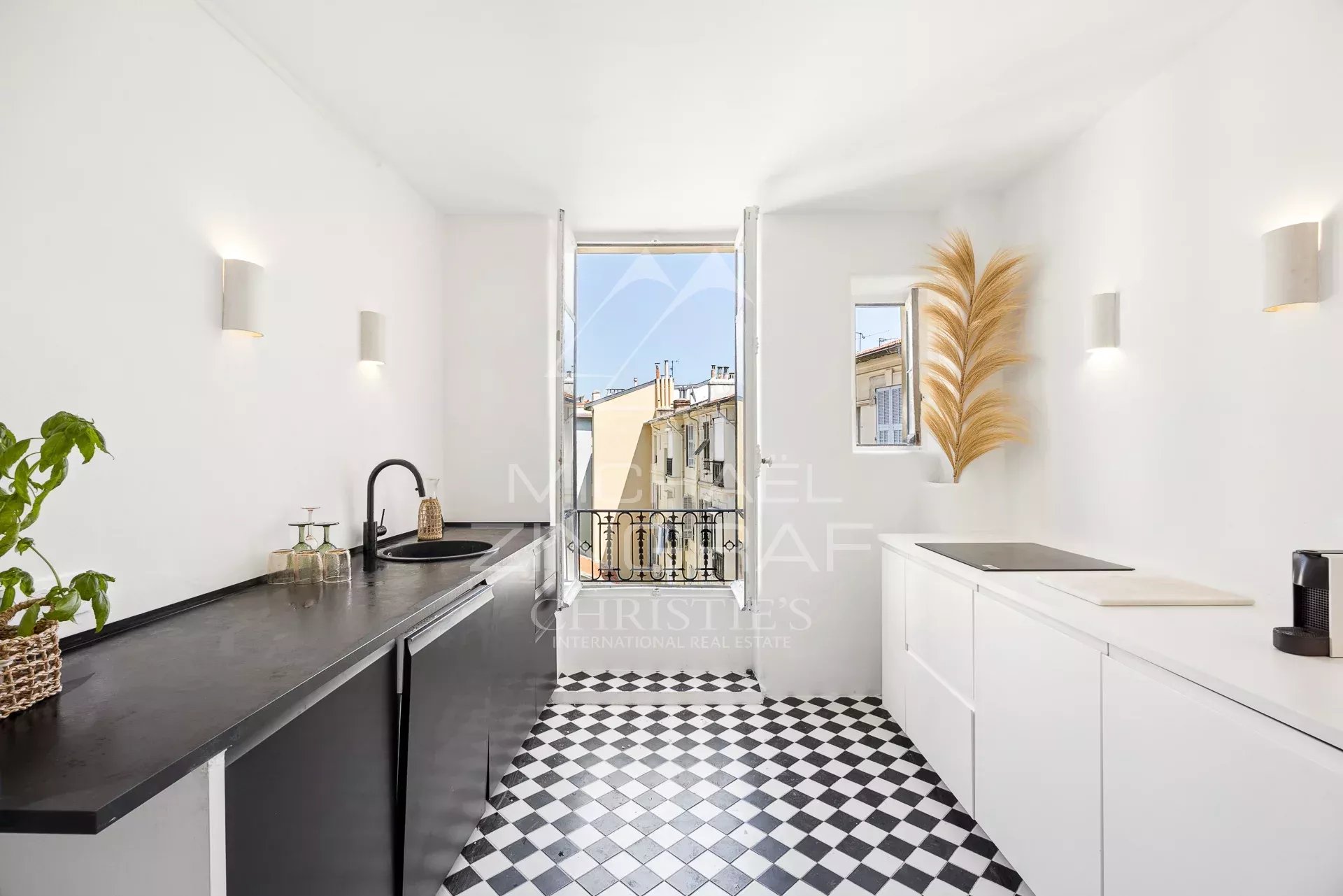 Modern kitchen with black and white tiles, view over the rooftops of Nice.