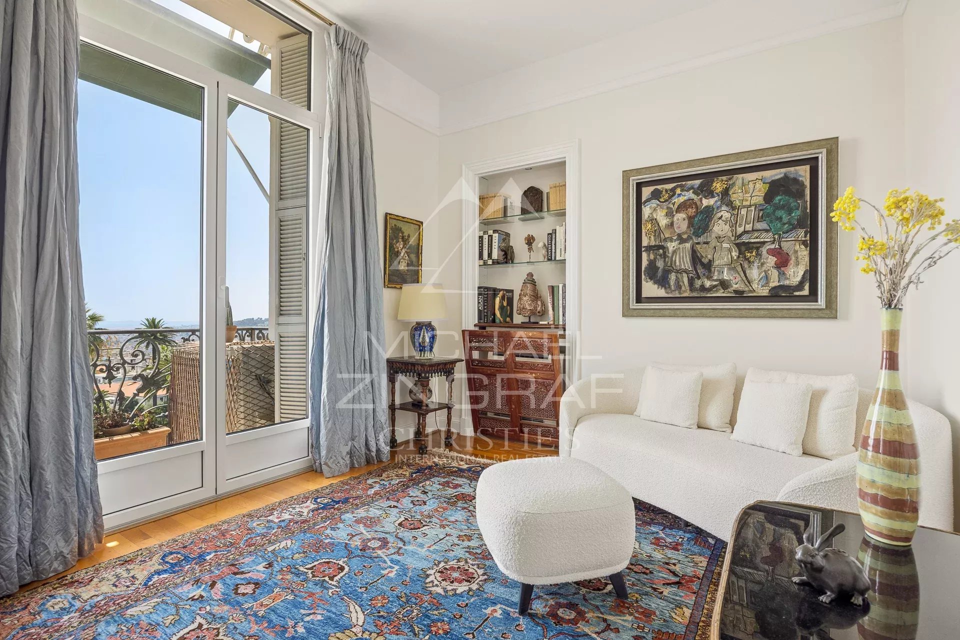 Intérieur d'un appartement de 165 m² à Nice avec vue sur la mer, salon élégant et décoration artistique.