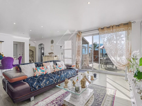 Intérieur d'une propriété familiale à Colomars, salon lumineux avec canapé et accès à la terrasse.