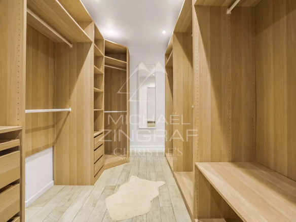 Intérieur d'un dressing spacieux en bois avec étagères et bancs.