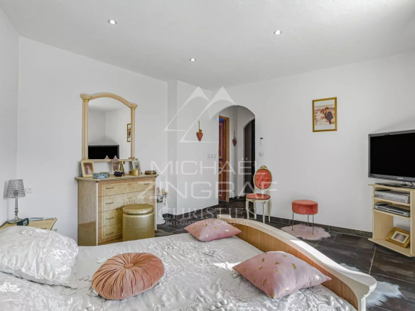 Chambre d'une propriété familiale à Colomars, avec lit, miroir et télévision.