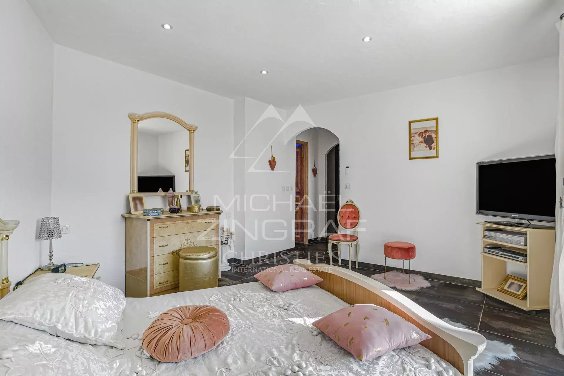 Chambre d’une propriété à Colomars Chambre d'une propriété familiale à Colomars, avec lit, miroir et télévision.
