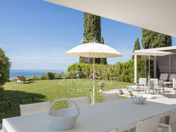 Terrasse d'un appartement à Nice avec vue sur la mer, mobilier extérieur et parasols.