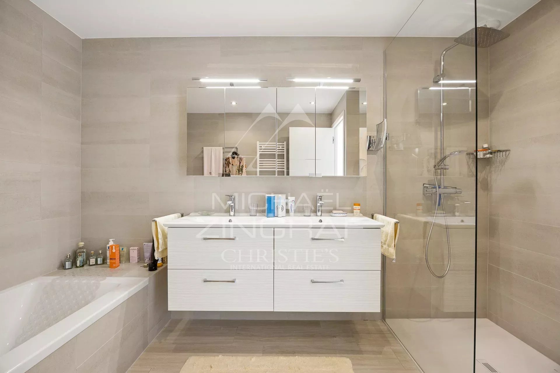 Salle de bain moderne Salle de bain moderne avec baignoire et douche, décor beige, miroir et rangements.