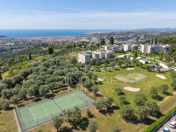 Vue aérienne d'un complexe résidentiel avec jardins, courts de tennis et vue sur la mer à Nice.