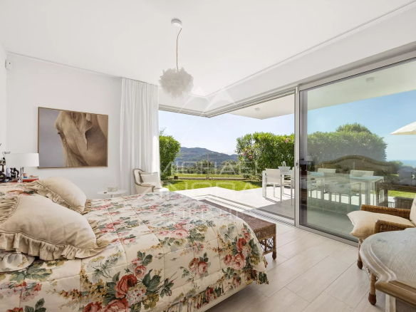 Chambre d'appartement avec vue sur jardin, décorée de fleurs, à Nice.